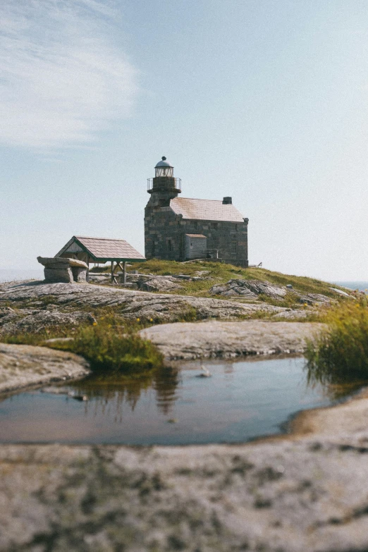 the lighthouse stands on a rock outcropping and overlooks a body of water