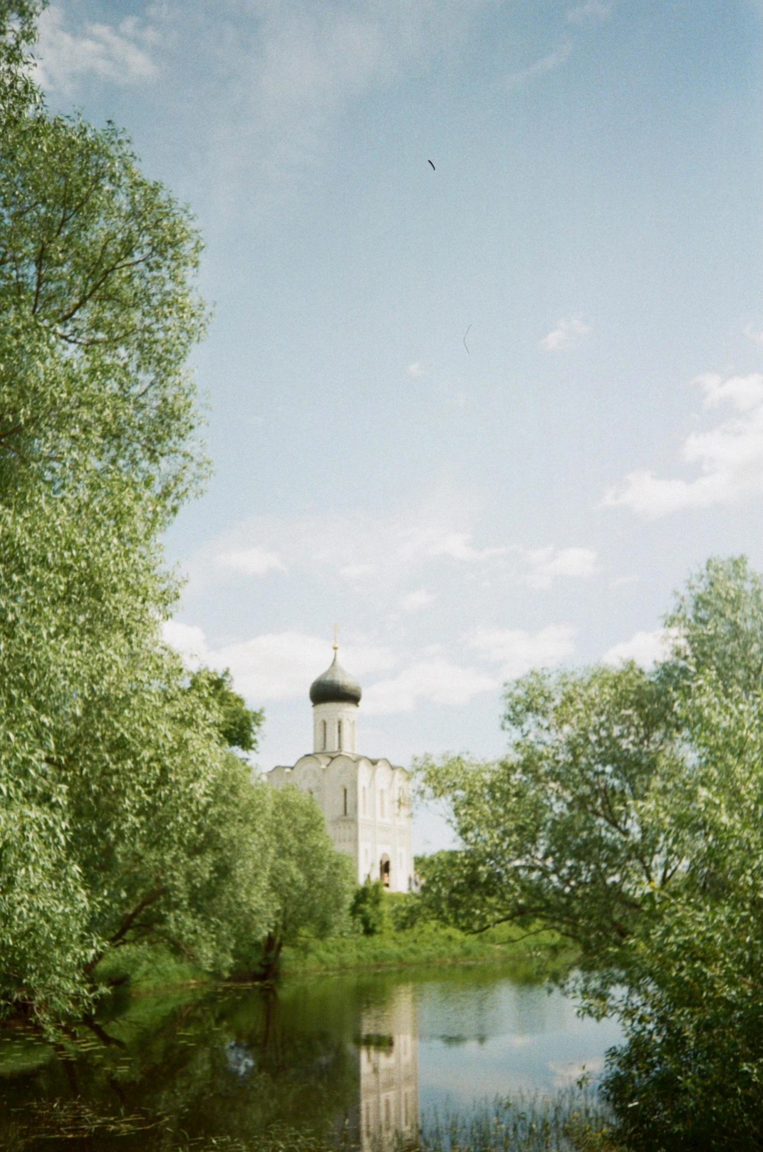 a small lake in front of a large white church