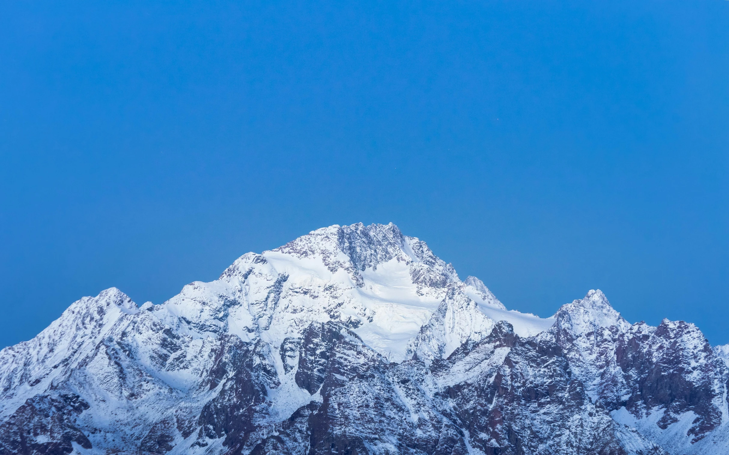 the top of a mountain is shown with snow