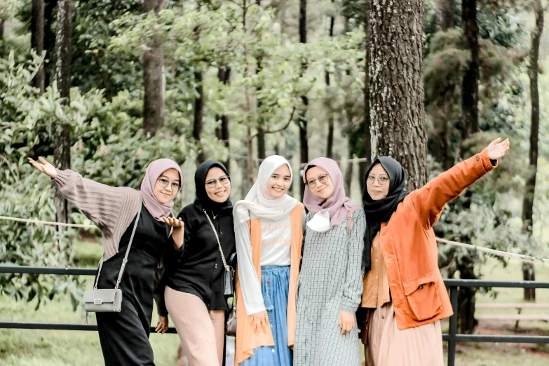 four women pose for a po in the woods