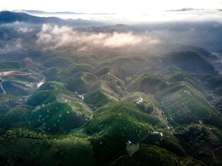 an aerial view of mountains and valleys with a city in the distance