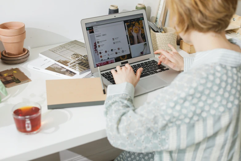 woman working on her laptop at a desk with coffee and other things