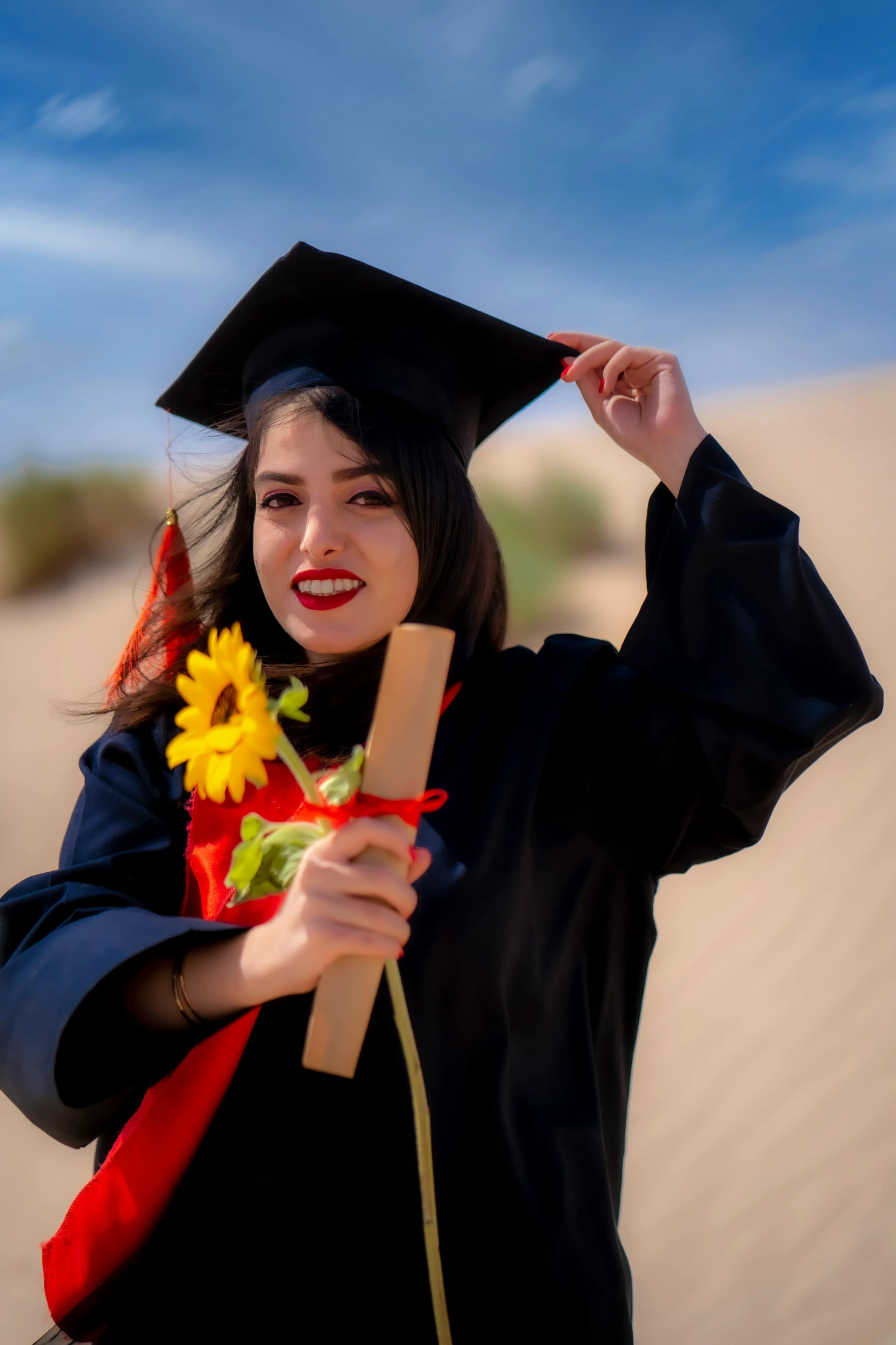 a girl in cap and gown holding a graduate's diploma