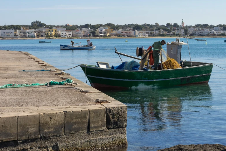 two boats are docked at a pier with the blue ocean in the background