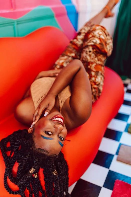 young woman with dyed skin on an orange chair