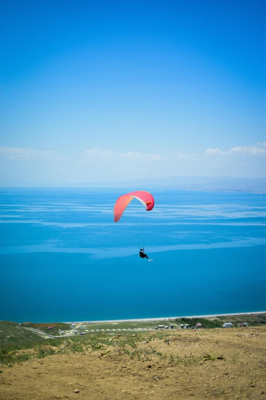 someone in the ocean flying a parachute over their head