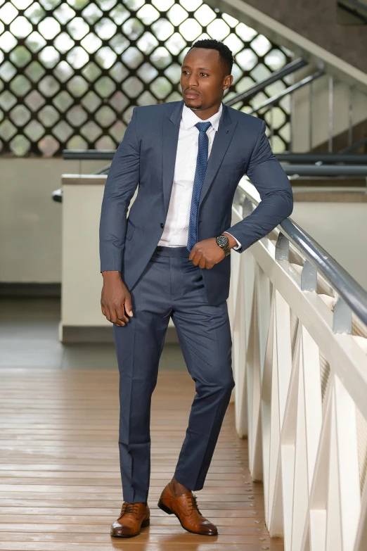 the man wearing a suit is standing by the railing