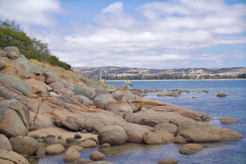 a body of water with some rocks on the shore