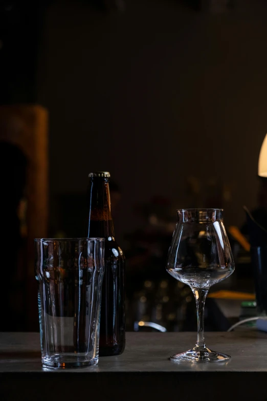 several glasses and a bottle are arranged on a table