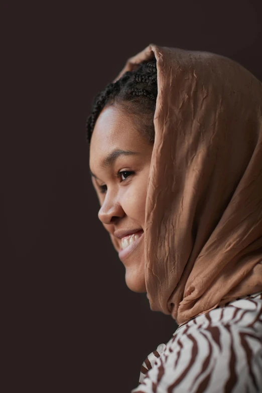 a woman smiling with a brown hoodie on