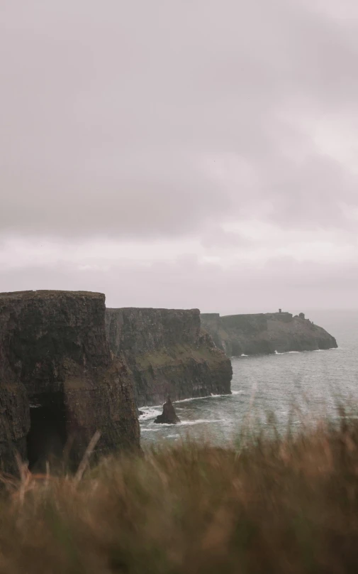 a long cliff overlooking a body of water and a lighthouse