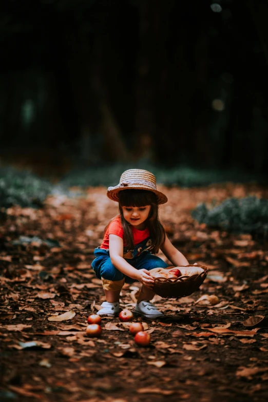 a little girl sitting in the woods picking fruits