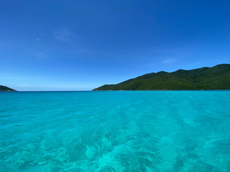 the beautiful blue water has the mountains in the distance