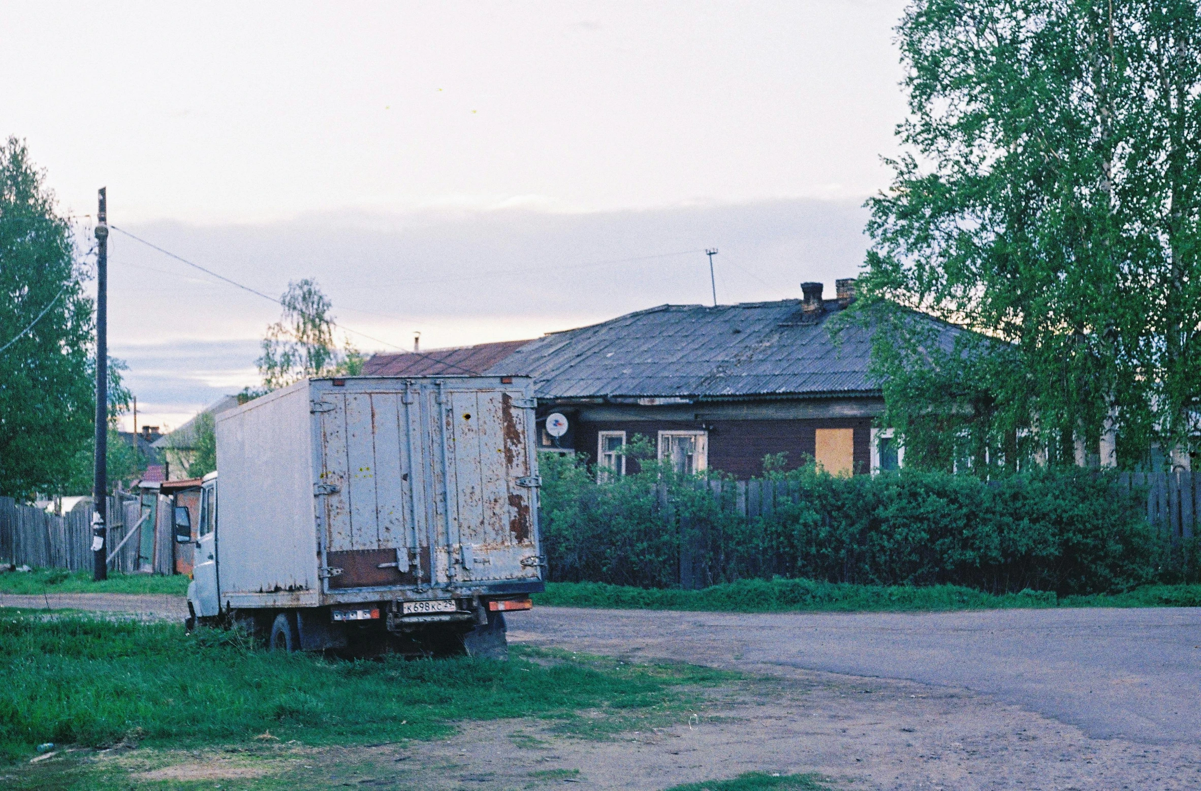 the large truck is driving down a street next to a house