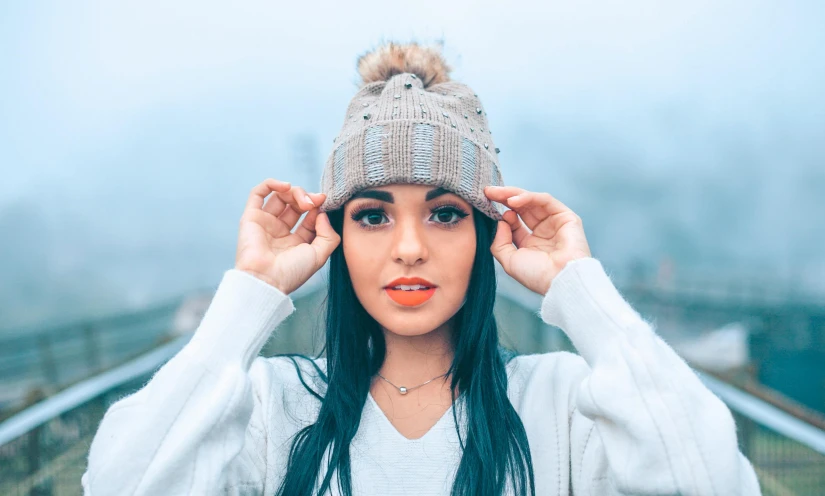 a young woman in winter clothing puts her head above her ear