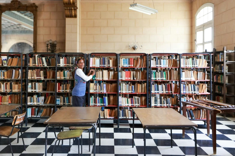 a woman is standing near bookshelves full of books