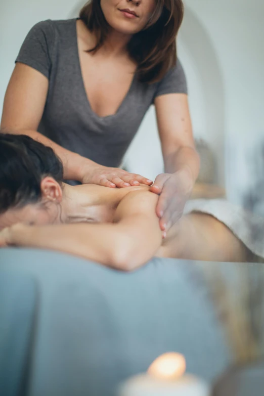 woman having spa massage at the foot of a mans sitting in a bed