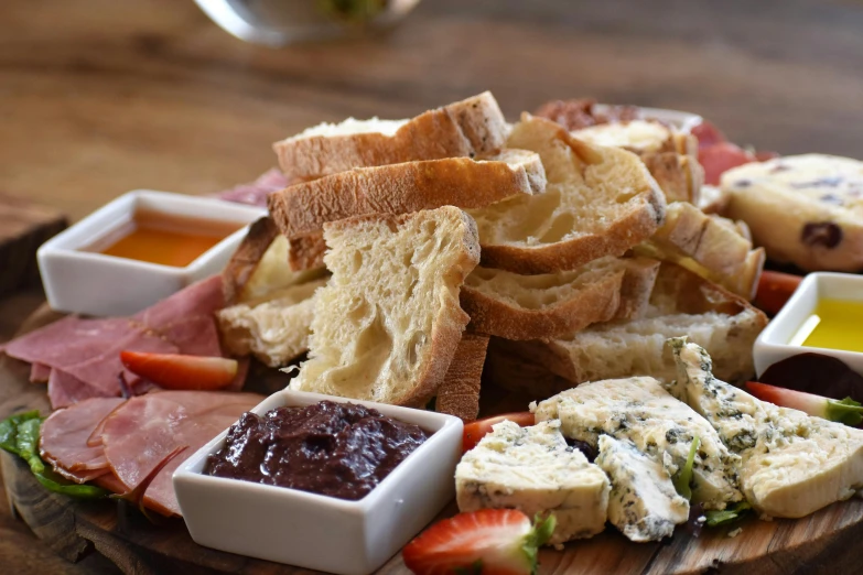 a plate filled with breads, fruit and dipping sauce