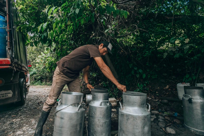 a man filling his gas cans with a hose