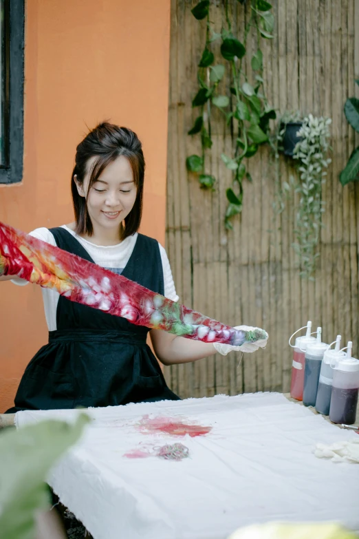 a girl holding paint and a big colorful object