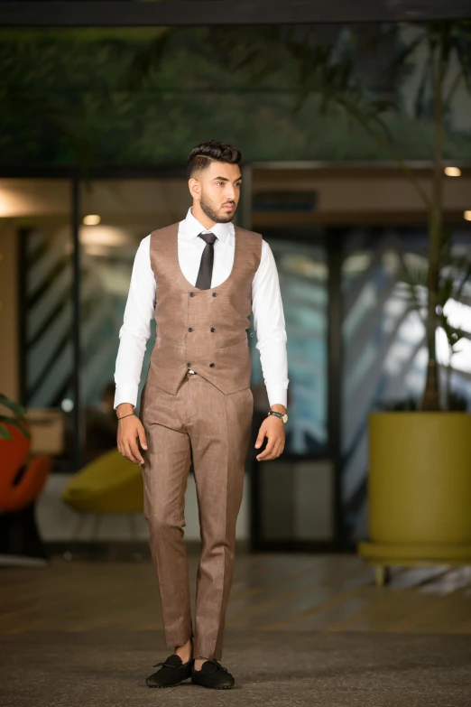 a man dressed in a brown suit standing