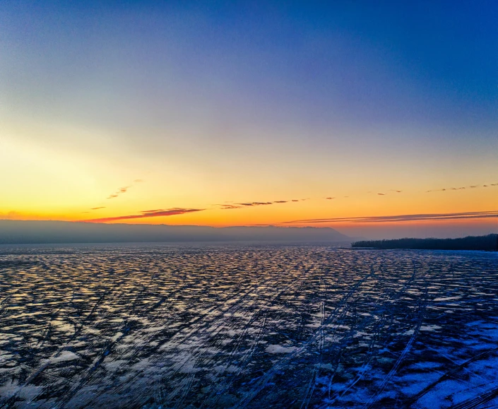 the sun sets over a body of water