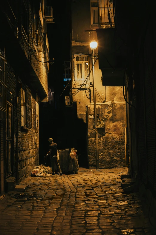 a man sitting down at night in front of a street