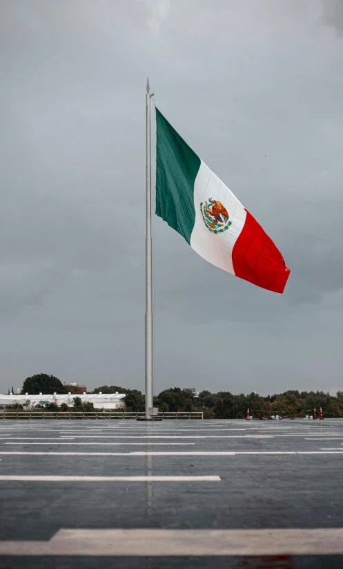 a flag pole sitting next to a parking lot