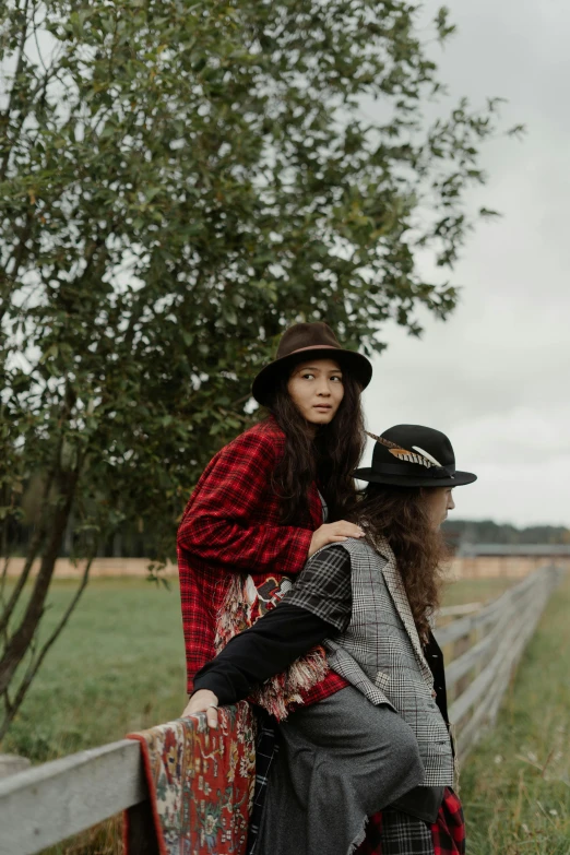 a person that is holding another person near a fence