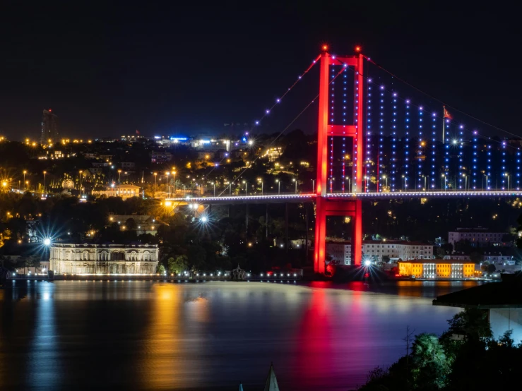 the suspension bridge has bright lights all over it