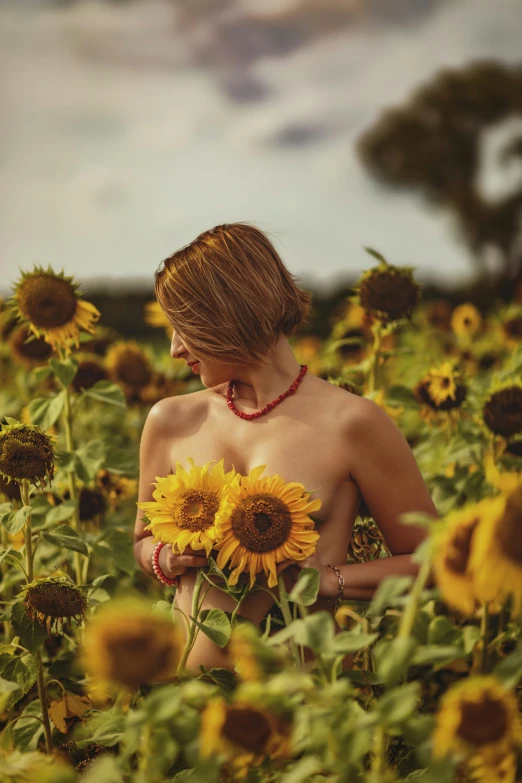 a beautiful lady in sunflowers field poses for a po