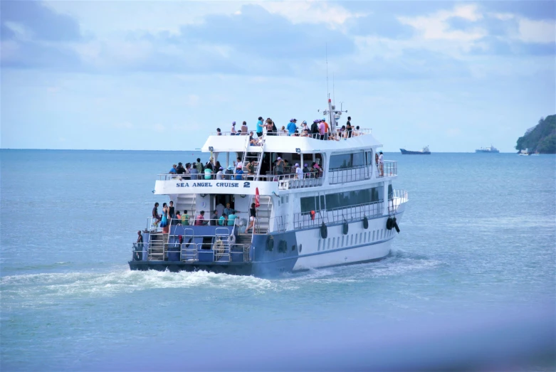 a white and blue boat in the ocean near trees