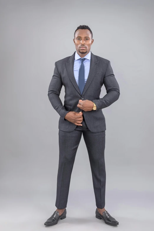 a black man in a gray suit is posing for the camera