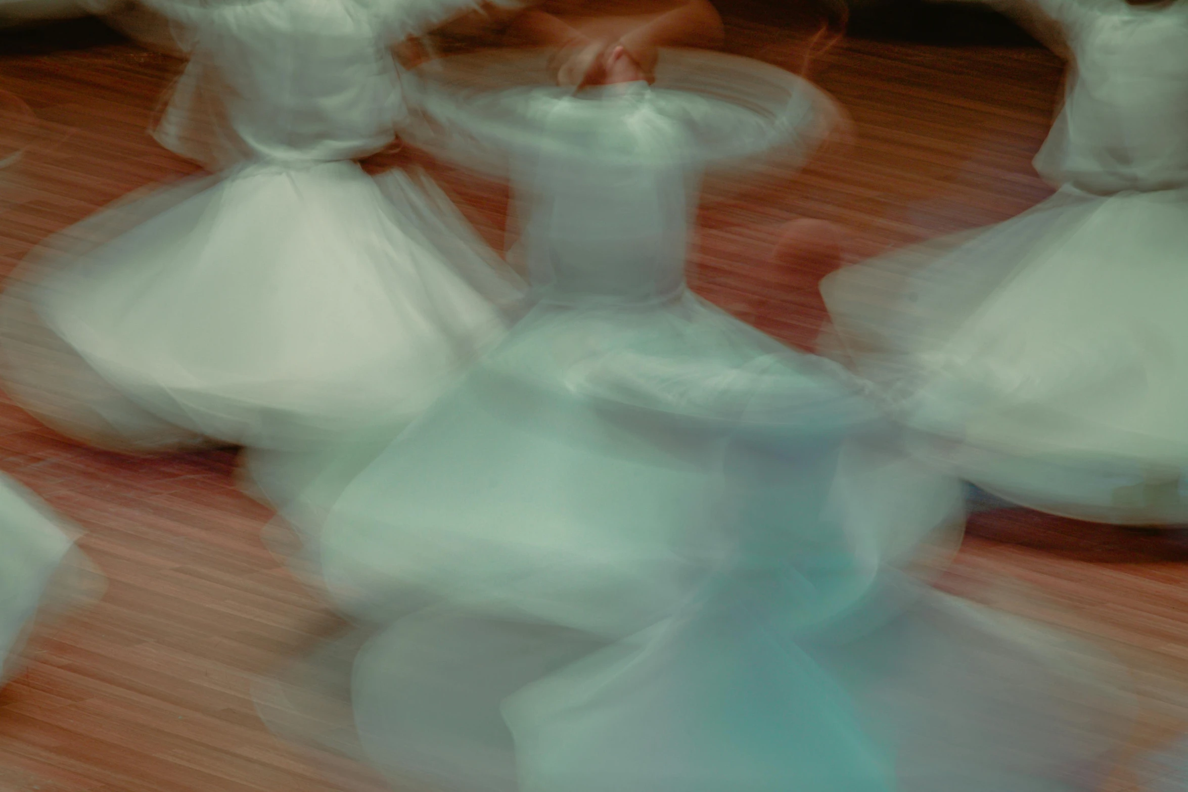 blurred pograph of several women wearing dresses and holding hands