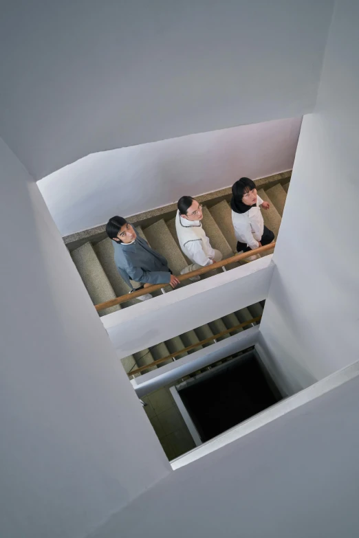 three people in sweaters are riding down the stairs