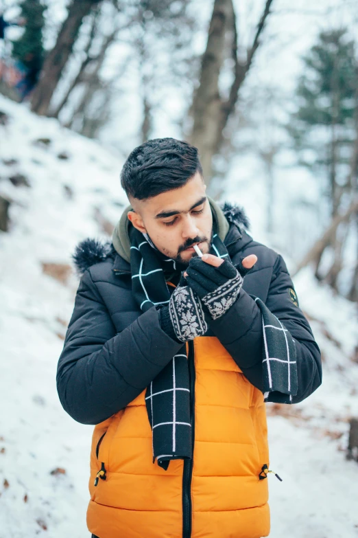 a man stands in the snow and smokes his cigarette