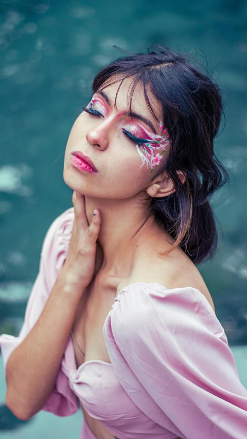 a woman with painted face stands in front of water