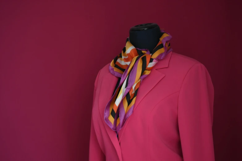 a mannequin wearing a bright colored jacket and scarf