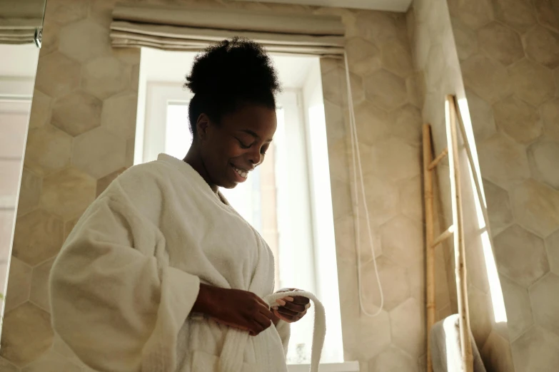 a woman dressed in white holding a smart device