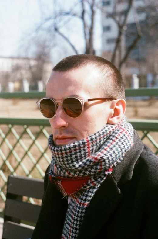 a man with sunglasses and a scarf around his neck