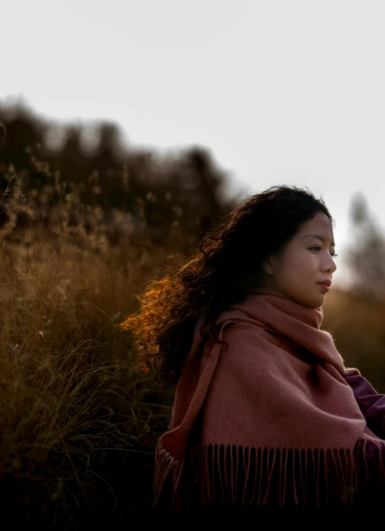 a girl in a long sleeved sweater is looking away