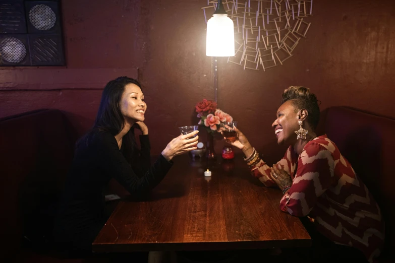 two people sitting at a table in a dimly lit room