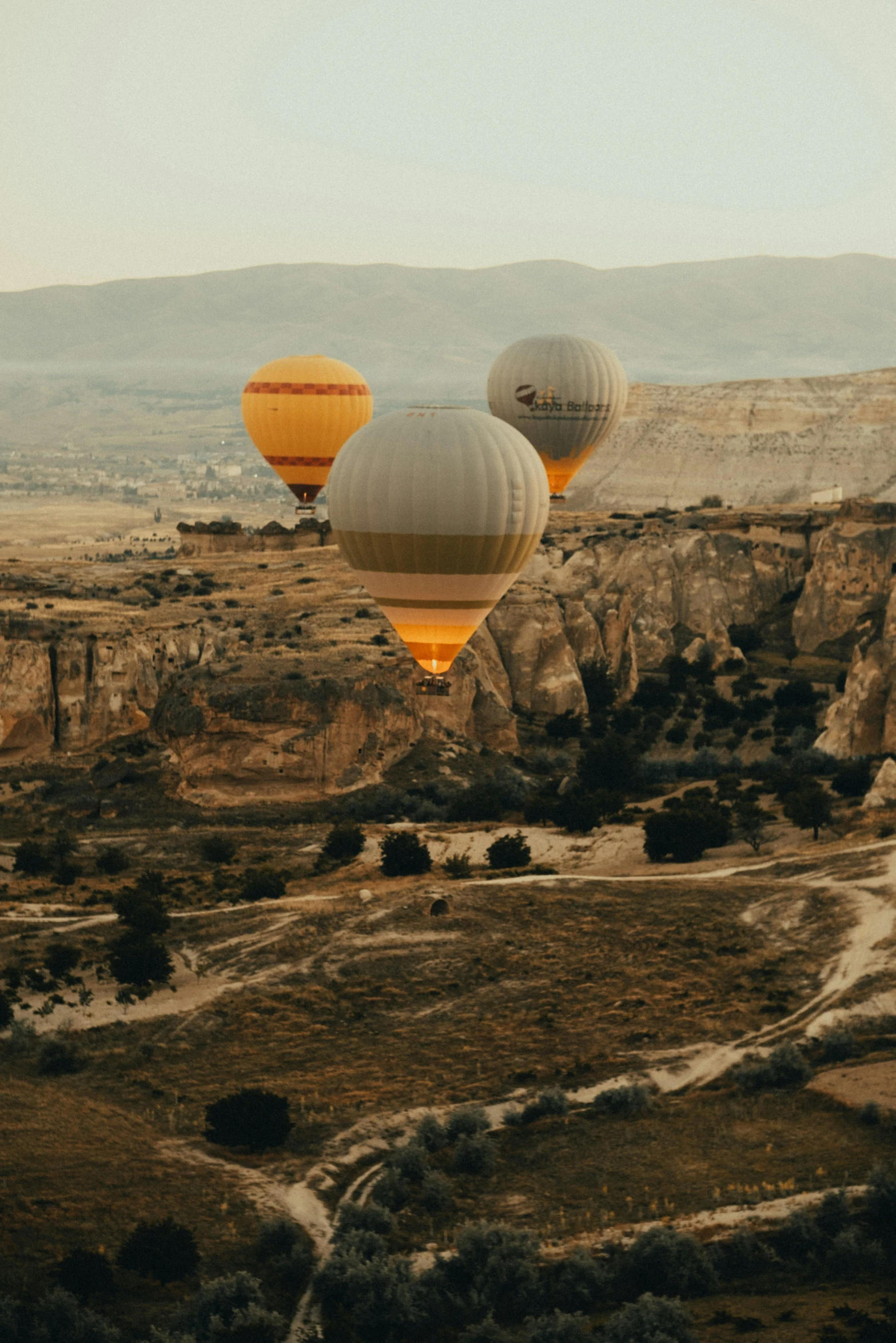 three  air balloons fly over the desert