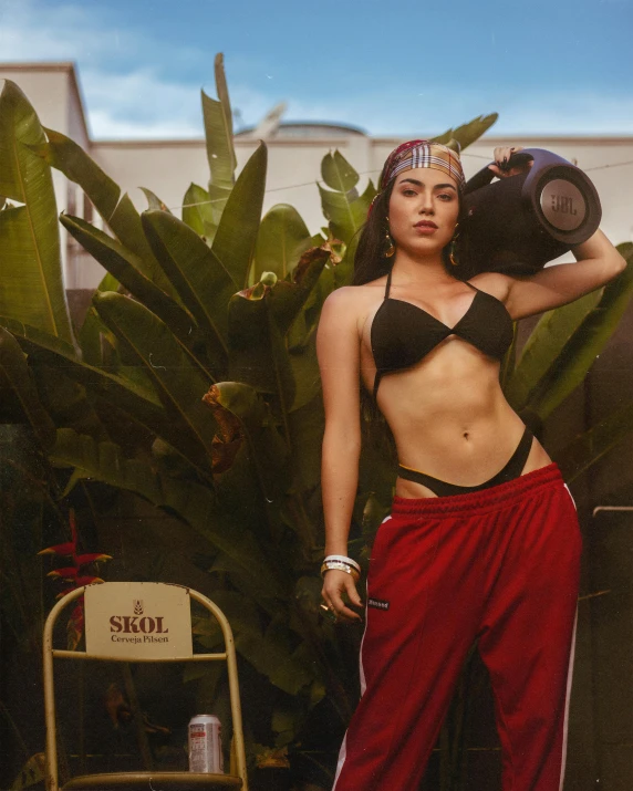 a person standing next to some plants and posing for a picture