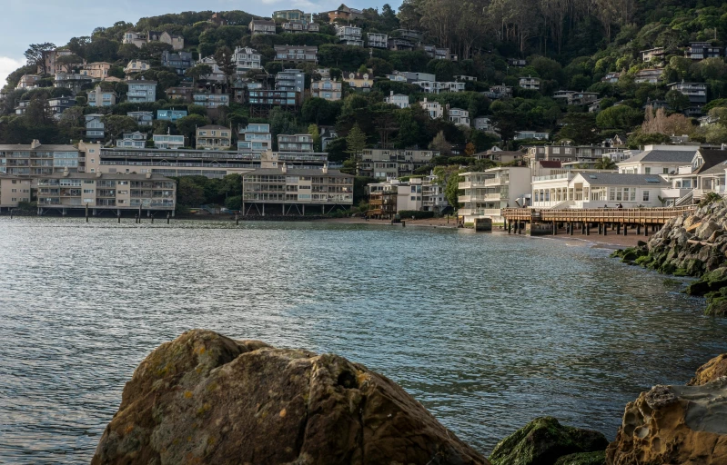 some buildings and rocks in front of some water