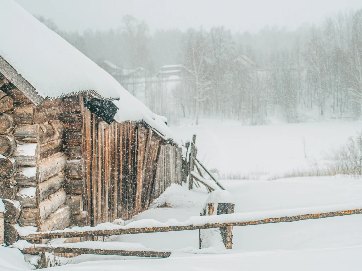 a cabin sits in the snow on a cloudy day