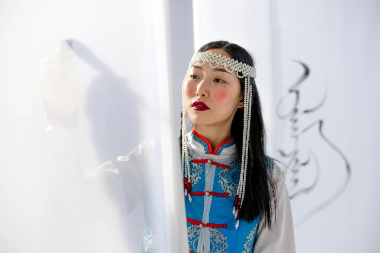 a woman in traditional dress holds a pole with a chain