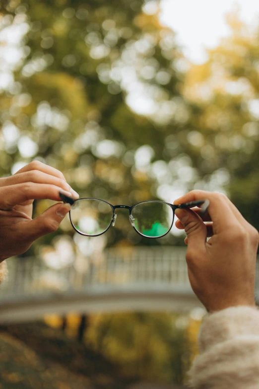 a woman holding on to her glasses as another person puts their hand over her eyes