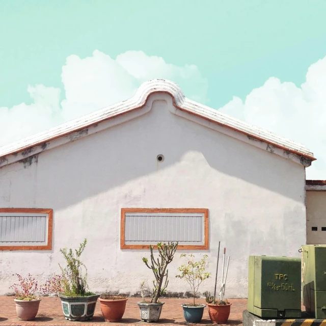 several large pots in front of a white building