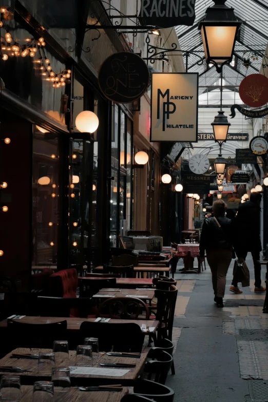 several tables in a restaurant with people walking by